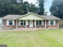 Charming one-story brick home featuring a well-manicured lawn and a welcoming front entrance at 6544 Bussell Way, Riverdale, GA 30274