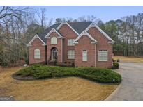 Charming two-story brick home with a well-manicured lawn and an arched entryway at 1442 Swiftwater Cir, Mcdonough, GA 30252