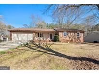Charming brick ranch-style home featuring an attached garage and a well-maintained lawn at 55 Helen Ln, Stockbridge, GA 30281