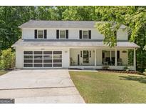 Charming two-story home featuring a welcoming front porch, modern garage door, and well-maintained landscaping at 1917 Lake Ridge Ct, Jonesboro, GA 30236