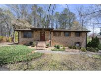 Charming brick home featuring shuttered windows, a covered front porch, and a neatly landscaped front yard at 5217 Hollyhock Rd, Douglasville, GA 30135