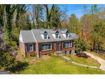Charming brick home featuring a classic design, well-maintained lawn, mature trees, and inviting curb appeal at 2255 Beecher Sw Rd, Atlanta, GA 30311