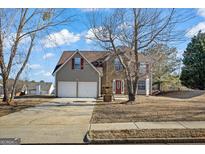 Charming two-story home featuring a stone facade, two-car garage, and a well-manicured lawn on a sunny day at 520 Easton Dr, Locust Grove, GA 30248