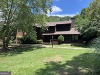 Charming two-story home featuring a well-maintained lawn and mature trees on a sunny day at 20 Fairway Ln, Peachtree City, GA 30269
