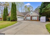 Charming brick and siding home featuring a spacious driveway and well-maintained landscaping at 324 Sue Ct, Temple, GA 30179