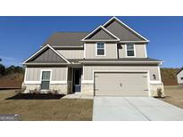 Charming two-story home featuring neutral siding, complementary roof, and an attached two-car garage at 465 Cantrell Drive, Dallas, GA 30157