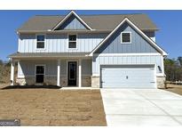 Charming two-story home featuring blue siding, a gray roof, a two-car garage, and a neatly manicured front lawn at 615 Cantrell Drive, Dallas, GA 30157