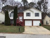 Charming two-story home with brick accents, two-car garage, and manicured landscaping at 5734 Wellborn Oaks Ct, Lithonia, GA 30058
