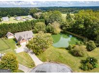 Stunning aerial view of home with pond and lush landscaping at 557 Arrowhead Cir, Rutledge, GA 30663
