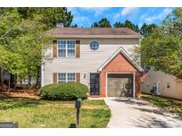 Two-story home with a charming brick facade and well-maintained lawn, creating a welcoming curb appeal at 6566 Chestnut Oaks Rdg, Lithonia, GA 30038