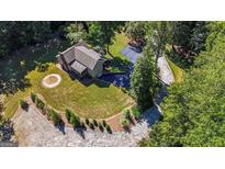 Aerial view of a home with a circular driveway, surrounded by lush greenery and mature trees at 250 Hester Rd, Carrollton, GA 30116