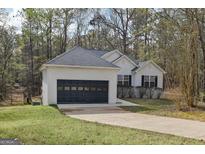 Charming single story home boasts an attached garage and well-maintained landscaping at 75 Bretts Bnd, Sharpsburg, GA 30277