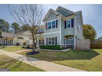 Charming two-story home with light green siding, dark shutters, and a well-manicured lawn on a sunny day at 509 Cowpens Rd, Social Circle, GA 30025