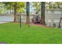 Charming brick home featuring a lush green lawn and a cozy front porch at 518 Hammett Dr, Decatur, GA 30032