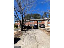 Brick townhouse complex with a gray concrete driveway and sparse winter landscaping at 8023 Creekstone Way, Riverdale, GA 30274