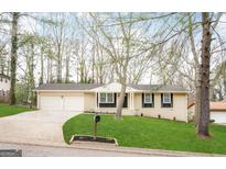 Charming single-story home featuring a well-manicured lawn and an attached two-car garage at 2017 Lindsey Ln, Decatur, GA 30035