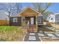 Charming home with a brick porch, exposed rafter tails and landscaped front yard at 1101 Oak Knoll Ter, Atlanta, GA 30315