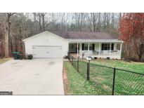 Charming ranch-style home featuring an attached garage and a welcoming covered front porch at 112 Honey Ln, Mcdonough, GA 30252