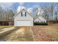 Charming single-Gathering home with a two-car garage and a cozy, landscaped front yard at 1103 Larkspur Dr, Locust Grove, GA 30248