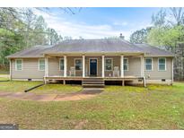 Charming ranch-style home featuring a welcoming front porch with columns and rocking chairs at 575 Chuli Rd, Locust Grove, GA 30248
