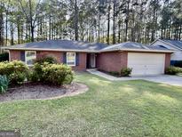 Charming brick home with a well-manicured lawn, inviting curb appeal, and attached two-car garage at 116 Glendale Dr, Peachtree City, GA 30269