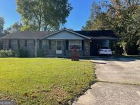 Charming one-story brick home with a covered carport and a well-maintained front yard at 266 Ridge Trl, Riverdale, GA 30274