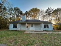 Charming single-story home with a covered front porch and large front yard surrounded by mature trees at 117 Old Stagecoach Rd, Carrollton, GA 30116