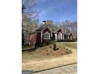 Charming brick home featuring manicured landscaping and a classic architectural design with a well-maintained lawn at 9039 River Bend Ct, Villa Rica, GA 30180