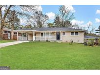 Charming brick home featuring a well-manicured lawn and a covered front porch at 3065 Glendale Ct, Decatur, GA 30032