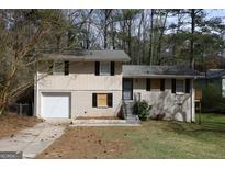 Two-story house with a garage, front lawn, and some trees around the house at 4044 Lindsey Dr, Decatur, GA 30035
