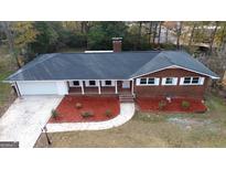 Charming brick ranch home with a well-manicured front yard and attached garage at 1351 John Robert Dr, Morrow, GA 30260