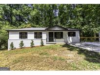 Charming single-story home featuring a brick foundation, black trim, and a newly landscaped yard at 2145 Venesa Cir, Austell, GA 30168
