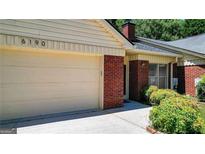 Home exterior featuring a brick facade, attached garage, and well-maintained landscaping at 6192 Douglas Manor Ct, Douglasville, GA 30134