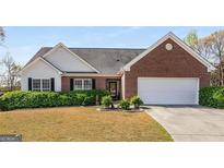 Charming brick and siding home featuring a well-manicured front yard and a two-car garage at 1232 Fountain View Dr, Lawrenceville, GA 30043