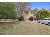 Two-story home with a combination of beige siding and red brick exterior with a driveway and a lawn at 1475 Keystone Dr, Suwanee, GA 30024