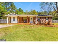 Charming single-story brick home featuring a welcoming front porch and well-maintained lawn at 2079 Leguin Mill Rd, Locust Grove, GA 30248