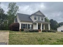 Charming two-story home featuring a covered front porch and well-maintained landscaping at 50 Autumn Ct, Covington, GA 30016