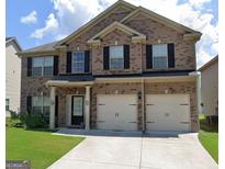 Charming two-story brick home featuring a two-car garage, well-maintained lawn, and classic black shutters at 3620 Pickeral St, Fairburn, GA 30213