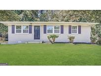 Charming single-story home with a well-maintained lawn and beautiful landscaping at 3410 Nw Adkins Rd, Atlanta, GA 30331