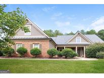 Charming single-Gathering home boasts a brick facade, well-manicured lawn, and a welcoming front porch at 1209 Richmond Rdg, Loganville, GA 30052