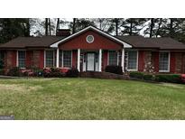 Charming red brick home with a well-manicured lawn and landscaped flowerbeds at 2760 The Fontainebleau Sw, Atlanta, GA 30331