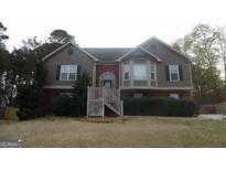 Charming two-story home featuring wood and brick, a landscaped yard, and a welcoming front entrance at 1742 Pine Fort Cir, Dacula, GA 30019
