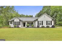 Charming white home featuring black shutters, a well-manicured lawn, and inviting landscaping for curb appeal at 2112 Highway 54, Moreland, GA 30259