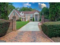 Impressive brick home featuring a well-manicured lawn and a long driveway with brick accents at 157 Glen Eagle Way, Mcdonough, GA 30253