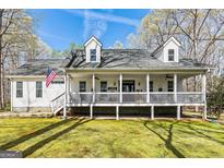 Charming two-story home featuring a welcoming front porch and American flag at 313 Dingler Rd, Moreland, GA 30259
