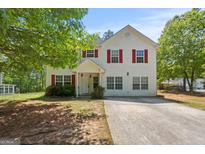 Inviting two-story home with red shutters, a well-manicured lawn, and mature trees at 60 Charlotte Blvd, Stockbridge, GA 30281