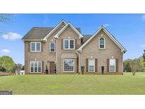 Two-story brick home featuring manicured lawn and multiple double hung windows at 198 Crestwood Rd, Tyrone, GA 30290