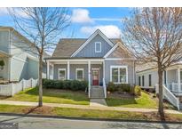 Charming home featuring a welcoming front porch, well-maintained lawn, and red front door at 5124 N Pratt St, Covington, GA 30014