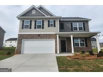 Two-story home features a two-car garage, a covered entry, and a mixed material facade, enhancing curb appeal at 161 Aster Ave, Locust Grove, GA 30248