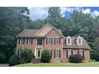 Beautiful brick home featuring traditional architecture and a well-manicured lawn and complementary landscape at 9340 Basswood Way, Jonesboro, GA 30236